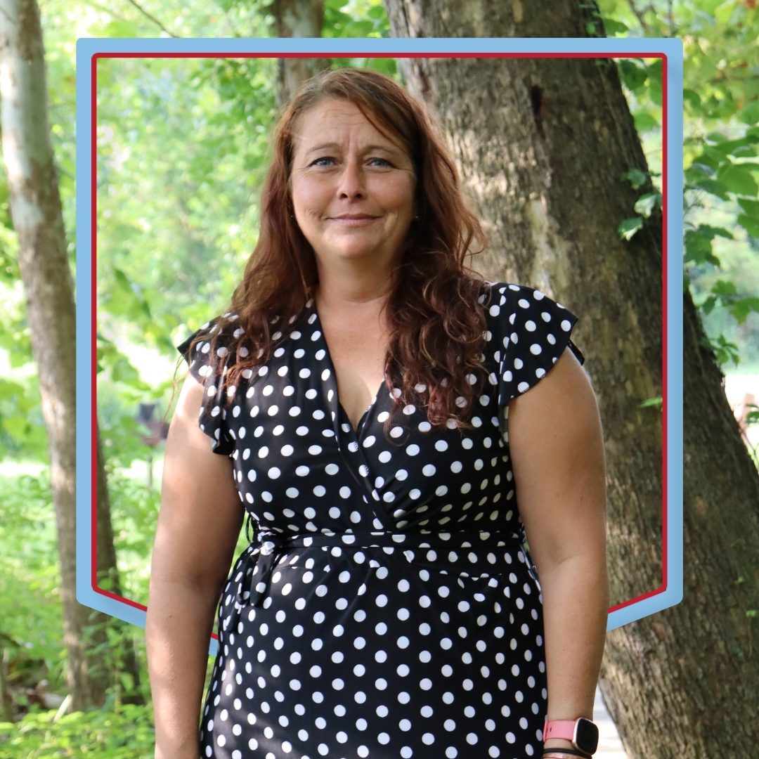 Joleen Rose poses with a wooded background.